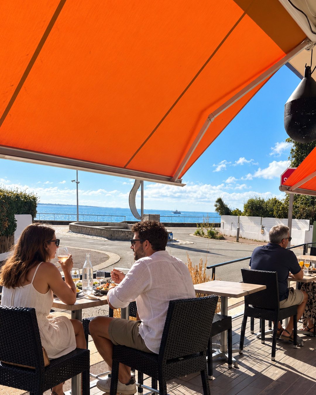 Terrasse de Chez Lulu avec vue sur l&rsquo;eau et convives attabl&eacute;s