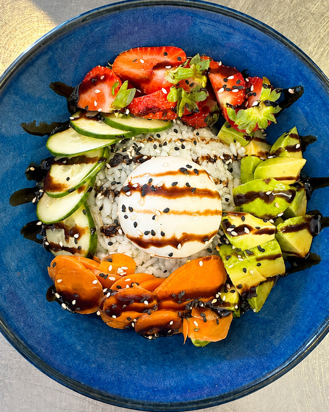 Bol de riz, burrata, avocat, concombre et fraises, vu du dessus